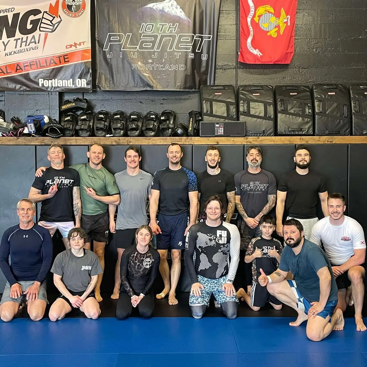 Mixed-age group at 10th Planet Portland including a young student, gathered on the mats