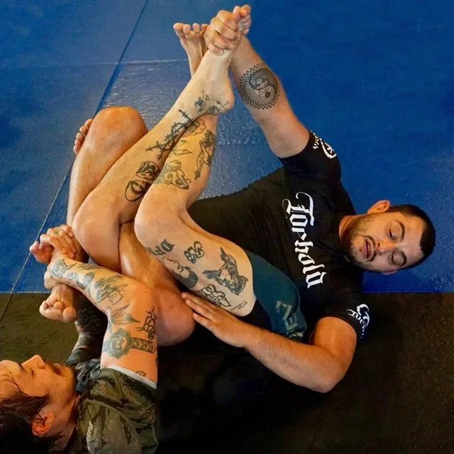 Close view of a leg entanglement between two grapplers on the mats